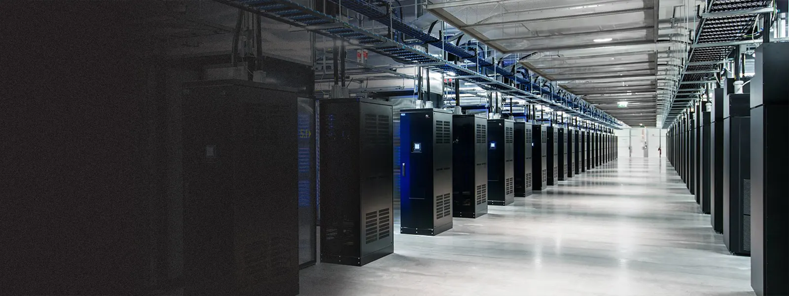 A long, brightly lit data center aisle lined with server racks